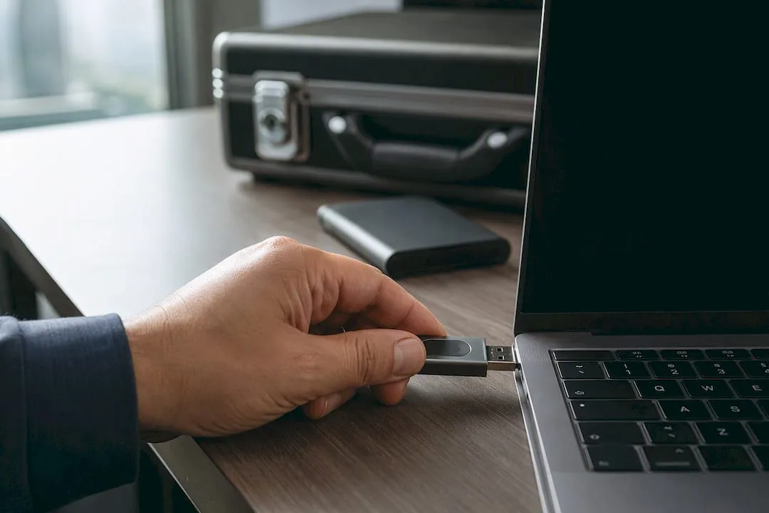 A hand plugging in a hardware security key